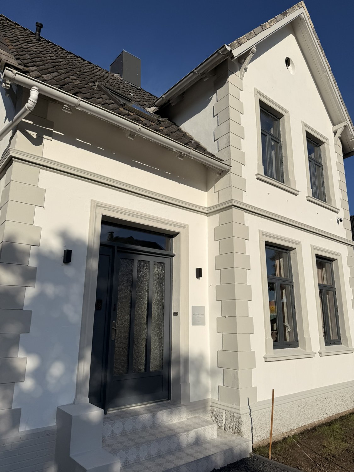 Helle Fassade und Eingang des Elbdreamer Gästehauses